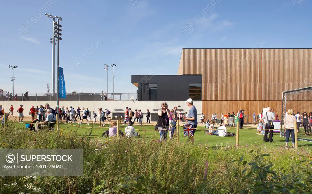 Eton Manor Olympic Park, London, United Kingdom. Architect: Stanton Williams, 2012. Frontal elevation with meadow, green and circulating spectators.
