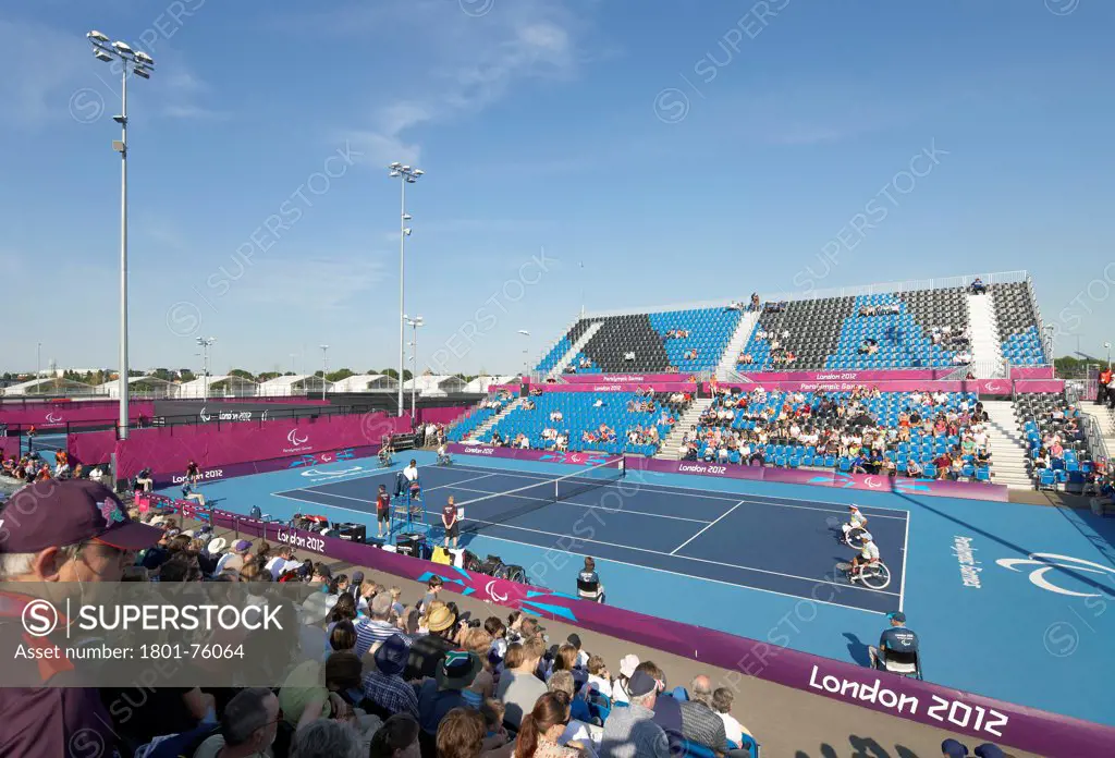 Eton Manor Olympic Park, London, United Kingdom. Architect: Stanton Williams, 2012. Elevated view of tennis court with tiers during competition.