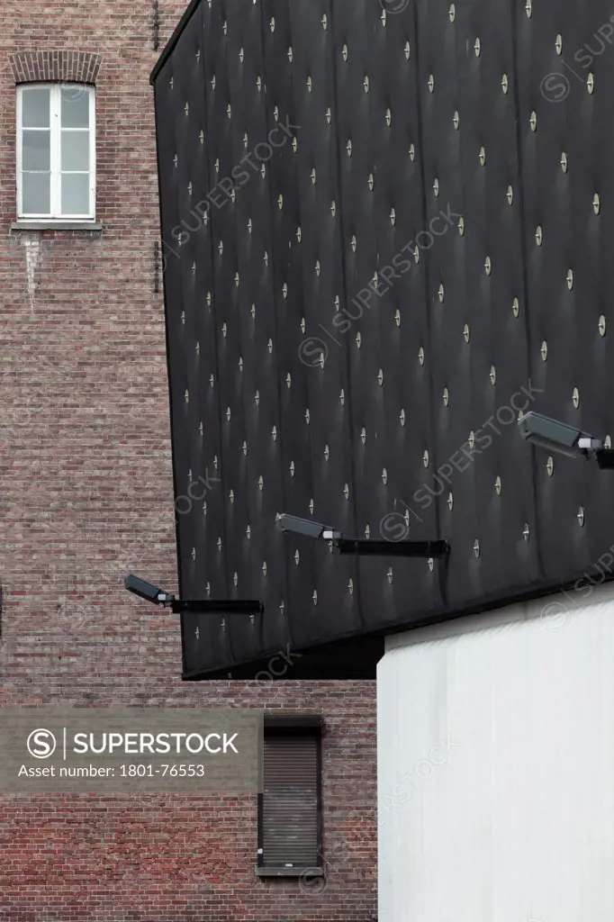 Detail of main elevation with black EPDM rubber skin and CDs and traditional brick building in background, Popcentre 013, Tilburg, Noord-Brabant, The Netherlands&#xA;Architects: Benthem Crouwel Architekten (1998)