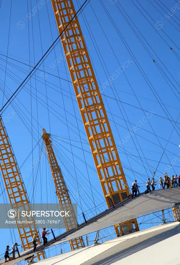 'Up at the O2'- High level walkway over the Millenium Dome, London, United Kingdom. Architect: Rogers Stirk Harbour + Partners, 2012. View from below showing figures on walkway.