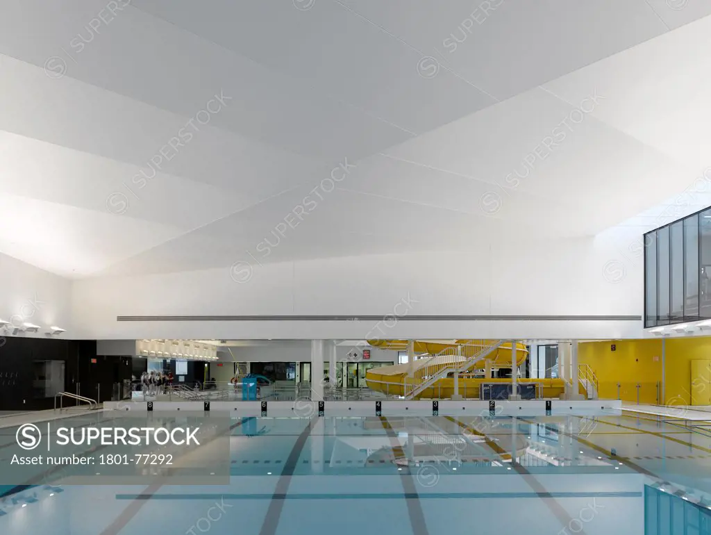 Centre Aquatique, St Hyacinthe, St Hyacinthe, Canada. Architect: Architecture, 2012. Main competition pool, diving boards, with swimmers.