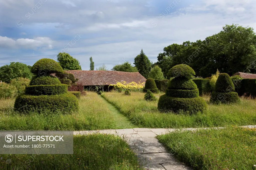 Great Dixter House & Garden, Northiam, United Kingdom. Architect: Edwin Lutyens, 1912. View of 'The Hovel' barn from the topiary lawn.