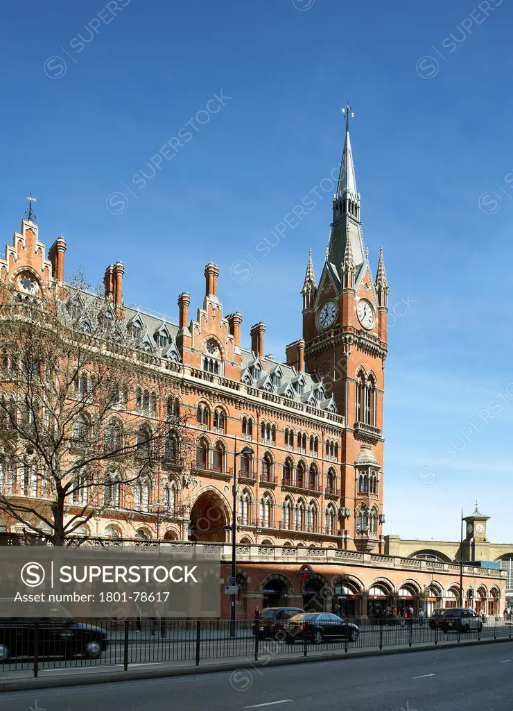 St Pancras Hotel, London, United Kingdom. Architect: Sir Giles Gilbert Scott With Richard Griffiths Arc, 2011. Clock Tower Facade Seen From Street With Shopping Arcade In Front.