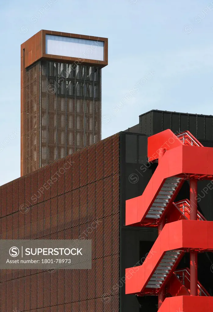 Energy Centre, London, United Kingdom. Architect: John Mcaslan & Partners, 2011. Signal Red Exterior Stairwell And Steel Facade With Chimney.