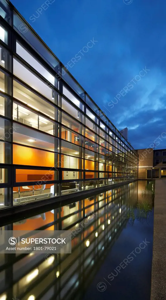 Postgraduate Statistics Centre And Learning Zone Building Lancaster University, Lancaster, United Kingdom. Architect: John Mcaslan & Partners, 2011. Perspective Of Facade Glazing And Water Reflection At Dusk.