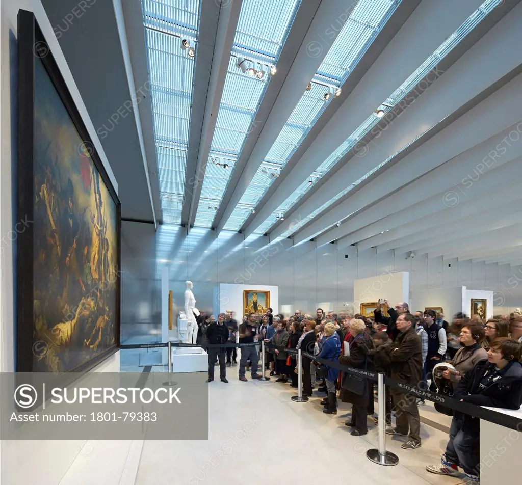 Musée Du Louvre  Lens, Lens, France. Architect: Sanaa, 2012. Delacroix Painting Attracting Large Crowd.