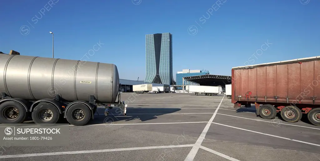Cma/Cgm Office Tower, Marseille, France. Architect: Zaha Hadid Architects, 2011. Panoramic View Of Lorry Parking Lot With View Of Tower Beyond.
