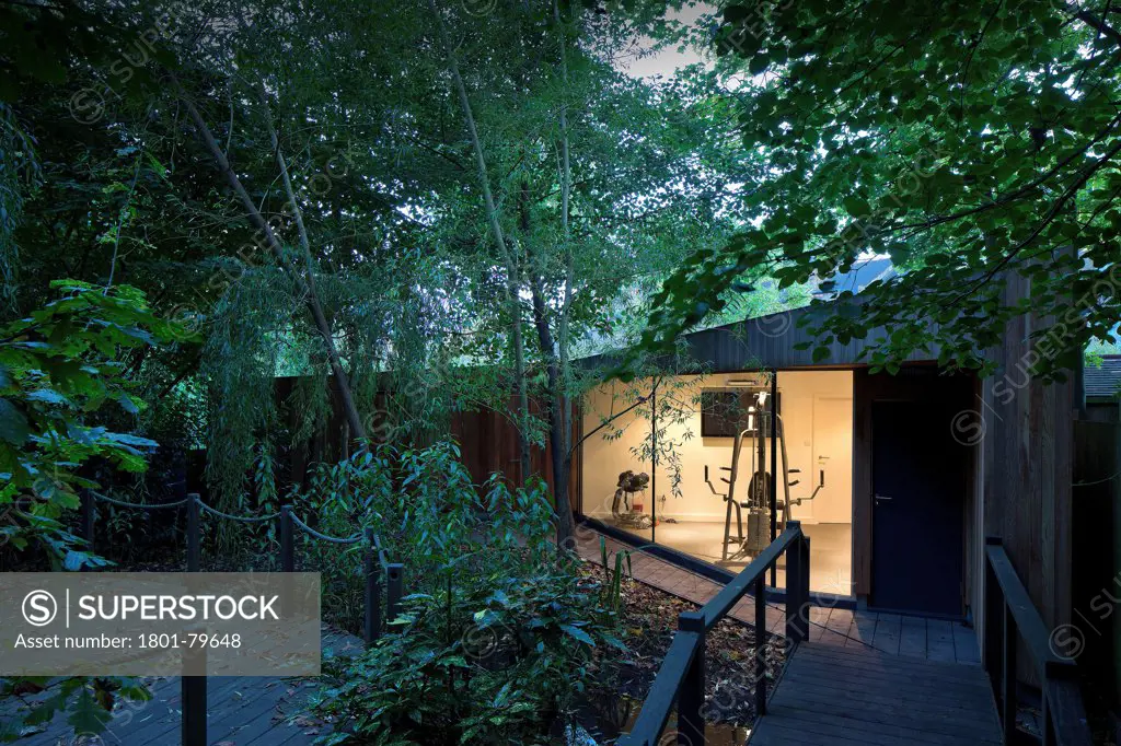 Private House Garden Extension, London, United Kingdom. Architect: Macarchitect, 2012. Looking Down Path And Over Bridge To Garden Gym At Dusk.
