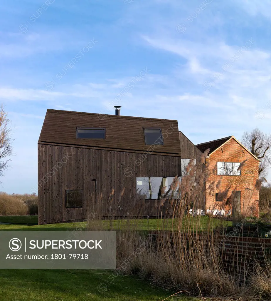 Hunsett Mill, Stalham, United Kingdom. Architect: Acme, 2010. Front Elevation With Reeds And Original Cottage.