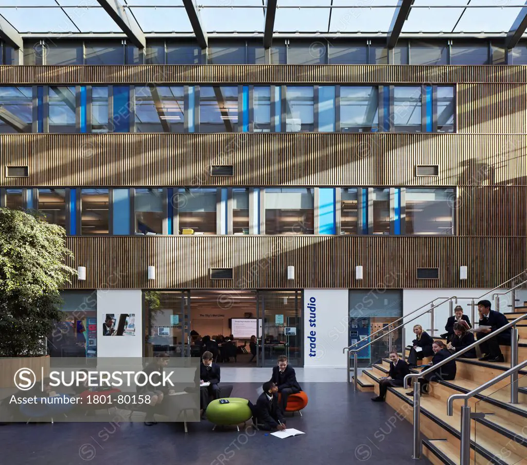 Stanley Park High School, Sutton, United Kingdom. Architect: Haverstock Associates Llp, 2012. Sunlit Atrium And Stairway With Informal Student Gathering.