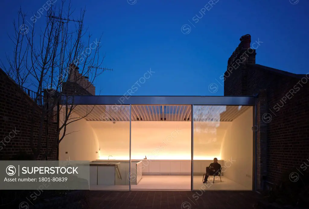 Two Stair House, London, United Kingdom. Architect: Gianni Botsford Architects Ltd, 2012. Twilight View Of Rooftop Extension With Figure Reading A Book.