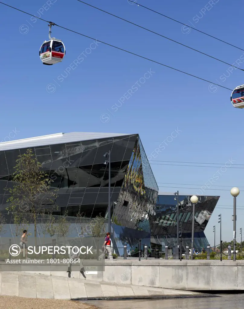 Siemens Urban Sustainability Centre - The Crystal, London, United Kingdom. Architect: Wilkinson Eyre Architects, 2012. Exterior View From Water Front With Cable Car.