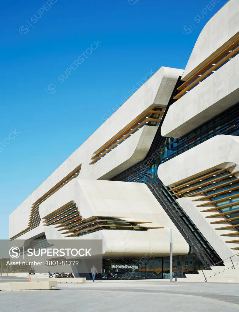 Pierresvives, Montpellier, France. Architect: Zaha Hadid Architects, 2012. Pierres Vives, Oblique West Facade Section Showing Entrance, Chamfered Concrete Levels, Recessed Glazing And Louvres.