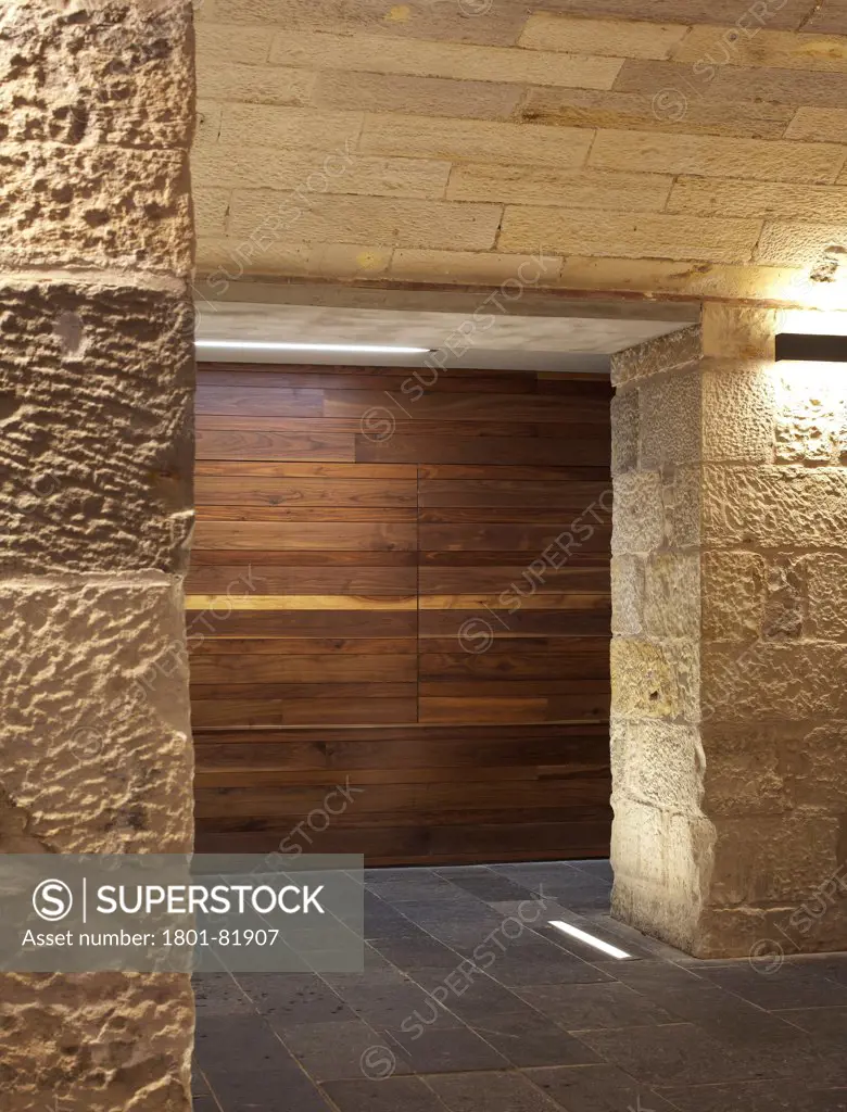 National Museum Of Scotland Redevelopment, City Of Edinburgh, United Kingdom. Architect: Gareth Hoskins Architects, 2011. View Of The Black American Walnut Door In The Main Entrance Hall With Sandstone Columns And Sunken Lighting.