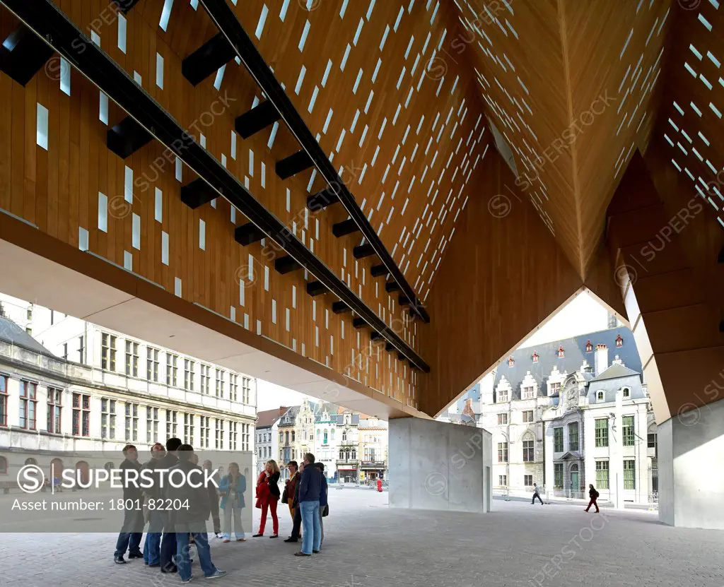 Ghent Market Hall, Ghent, Belgium. Architect: Robbrecht and Daem + Marie-Jose Van Hee, 2013. View through from underneath folded roof structure to urban context.