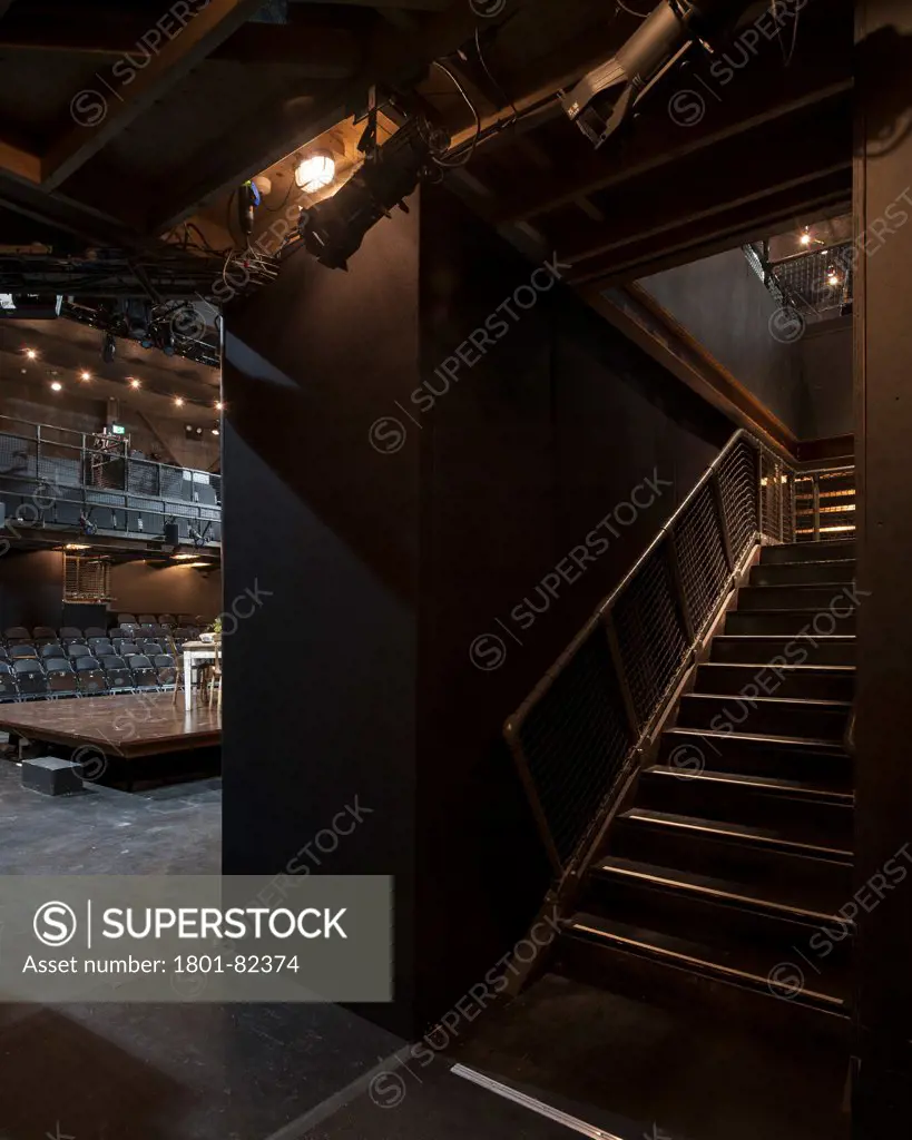 The Shed, London, United Kingdom. Architect: Haworth Tompkins Limited, 2013. Gloomy stairway with view of theatre interior.