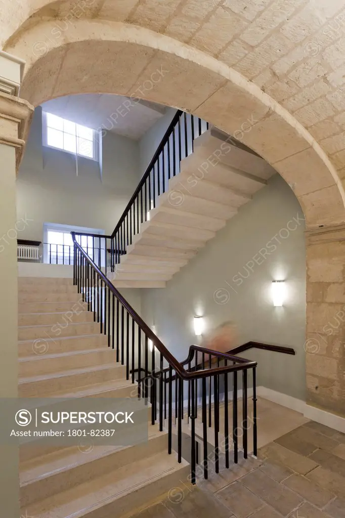 Oxford University's Radcliffe Humanities, Oxford, United Kingdom. Architect: Purcell Miller Tritton LLP, 2012. Staircase with stone wall.