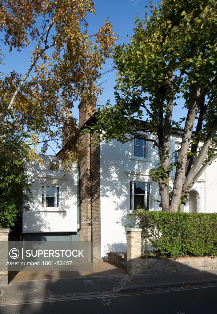 The Cut And Fold House, Twickenham, United Kingdom. Architect: Ashton Porter Architects, 2011. General view from the street showing the front of the house surrounded by trees.