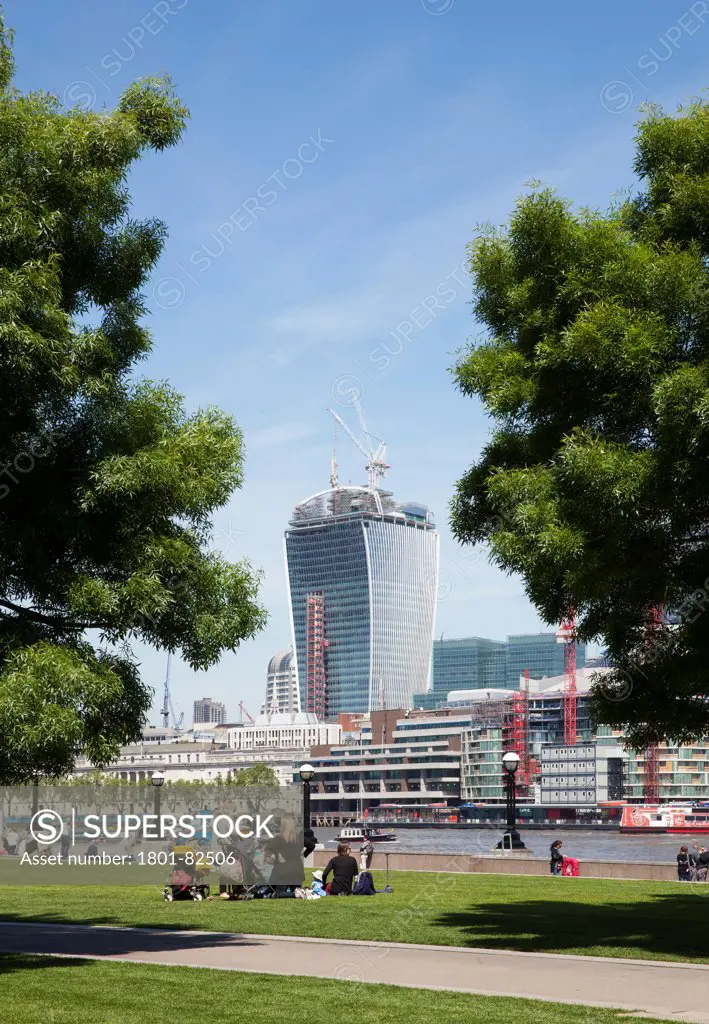 Walkie-Talkie - 20 Fenchurch Street, London, United Kingdom. Architect: Rafael Viñoly, 2013. Walkie-Talkie tower topping, view taken from the Thames embankment with people sitting in the for ground.