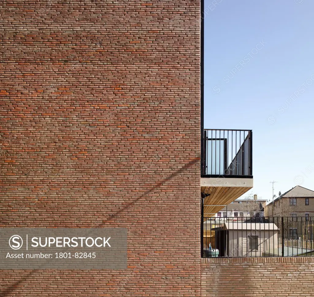 Library Street Affordable Housing, London, United Kingdom. Architect: Metaphorm Architects, 2012. Graphic view of sunlit brick facade and balcony.