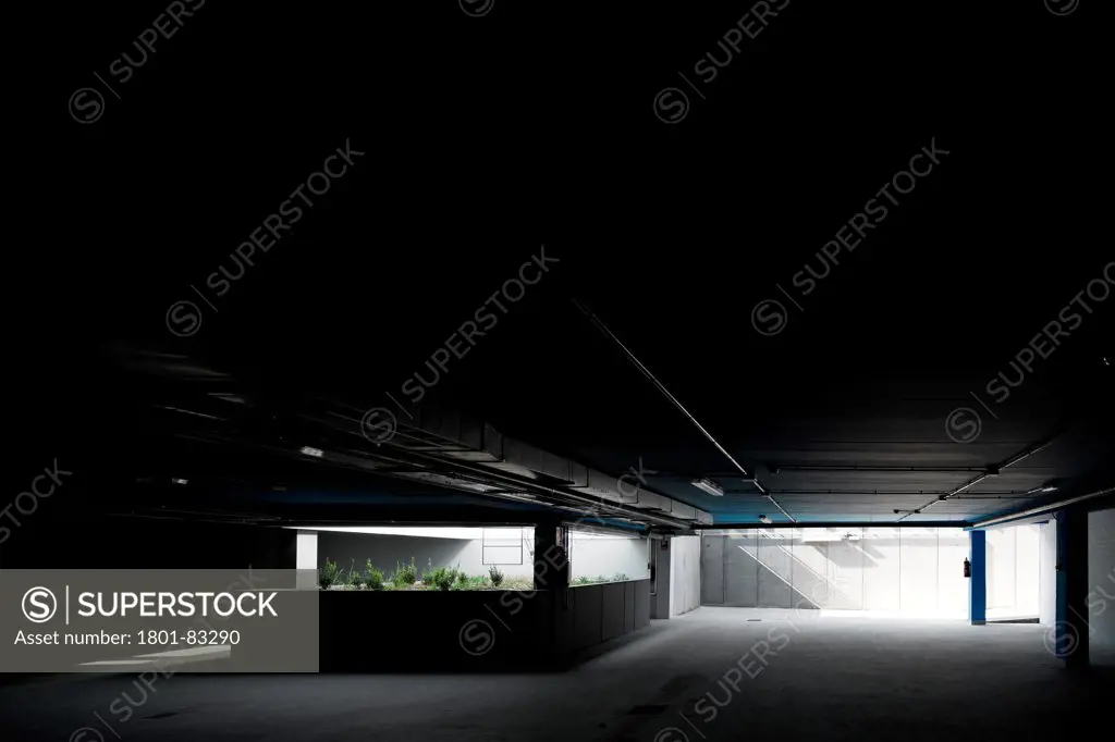 Burgos Art School, Burgos, Spain. Architect: Primitivo Gonzalez, 2011. View into dimly lit semi-basement floor.