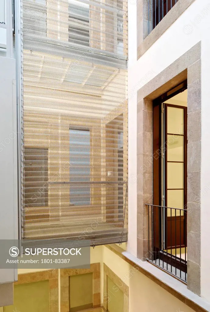 Apartments in Barcelona, Barcelona, Spain. Architect: LABA Arquitectura, 2013. Detail of see-through mesh in atrium.