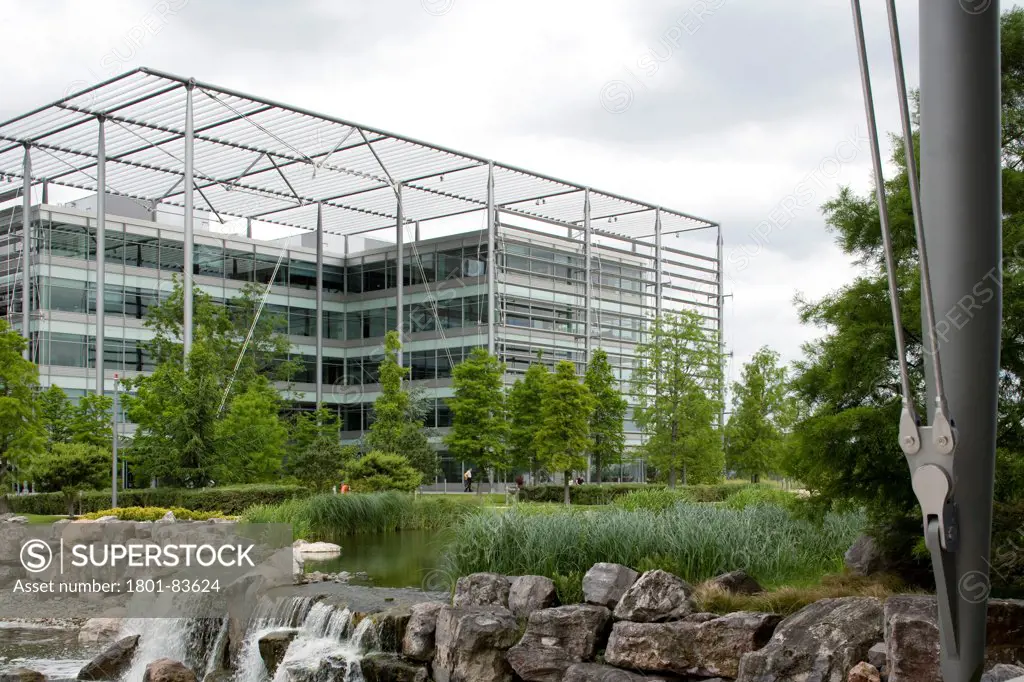 Chiswick Park, Chiswick, United Kingdom. Architect: RICHARD ROGERS PARTNERSHIP , 2007. View from pond showing the waterfall and offices background.