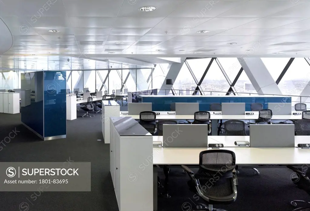Office space at 30 St Mary Axe (the Gherkin), London, United Kingdom. Architect: Michael O'Sullivan, 2012. General view of workstations and bespoke cabinets.