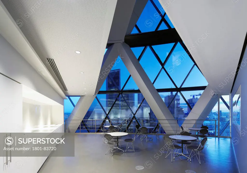 Office space at 30 St Mary Axe (the Gherkin), London, United Kingdom. Architect: Michael O'Sullivan, 2012. Dusk view of the seating / break-out area with views over the City of London.