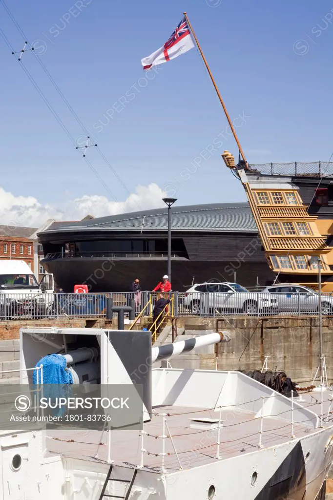 The Mary Rose Museum, Portsmouth, United Kingdom. Architect: Wilkinson Eyre Architects , 2013. Detail of museum and The Victory warship and Naval ship in Dry dock.