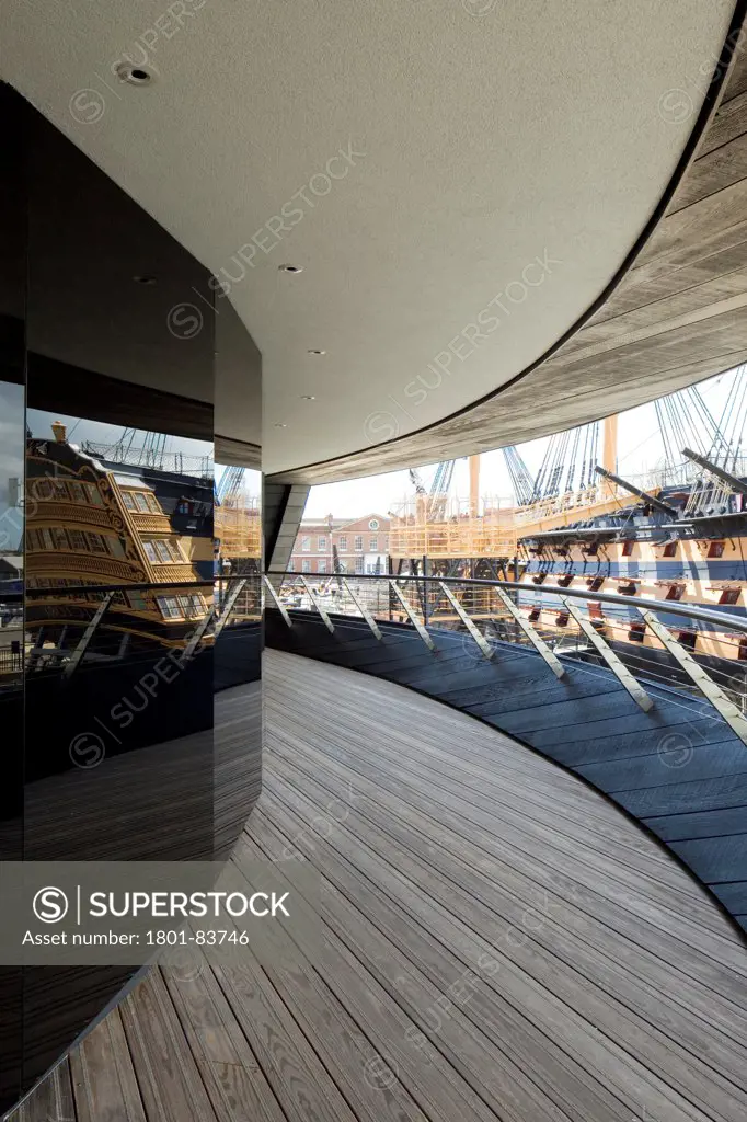The Mary Rose Museum, Portsmouth, United Kingdom. Architect: Wilkinson Eyre Architects , 2013. View along the museum balcony towards The Victory Warship.