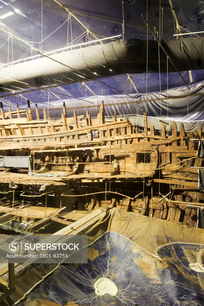 The Mary Rose Museum, Portsmouth, United Kingdom. Architect: Wilkinson Eyre Architects , 2013. Internal view of the Mary Rose in her protected dock.
