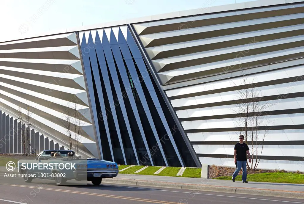 Eli & Edythe Broad Art Museum, Lansing, United States. Architect Zaha Hadid Architects, 2013. Street elevation of pleated steel facade with vintage convertible.