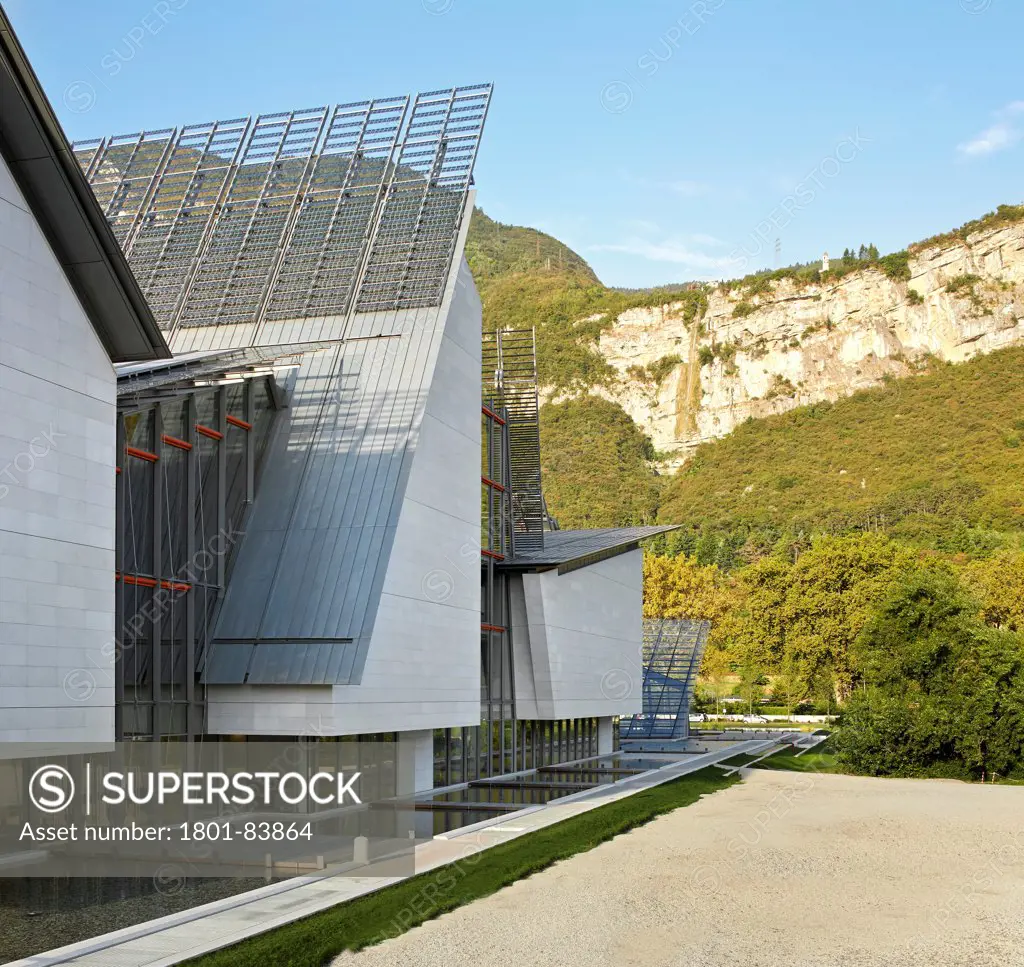 MUSEScience Museum, Trentino, Italy. Architect Renzo Piano Building Workshop, 2013. Elevated view of facade with landscaping and pitched roofs.