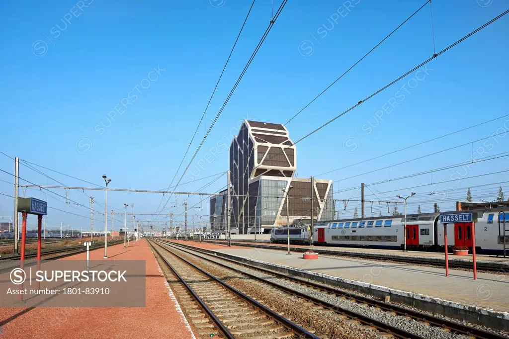 Court of Justice, Hasselt, Belgium. ArchitectJ. Mayer H. Architects, 2013. Railway platforms and tracks with Court of Justice beyond.