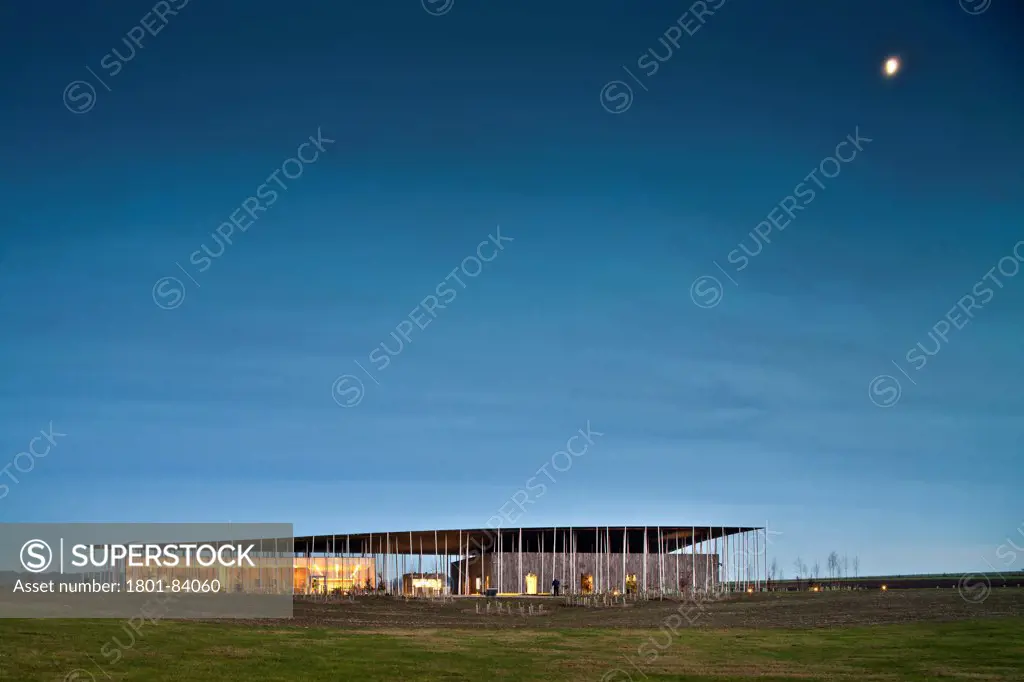 Stonehenge Visitor Centre, Amesbury, United Kingdom. Architect Denton Corker Marshall LLP, 2013. West elevation showing floating roof, cafe and museum areas with moon rising.