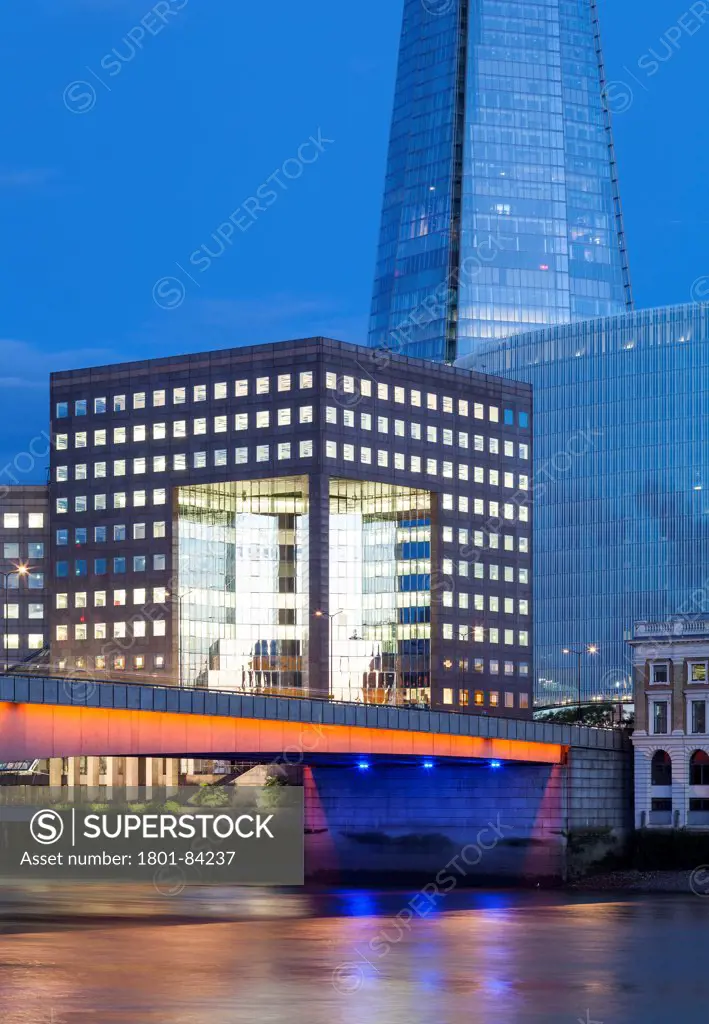 No.1 London Bridge, London, United Kingdom. Architect John S. Bonnington Partnership, 1986. View of the offices look across the river Thameswith the Shard in the background and London bridge lit up in the foreground.