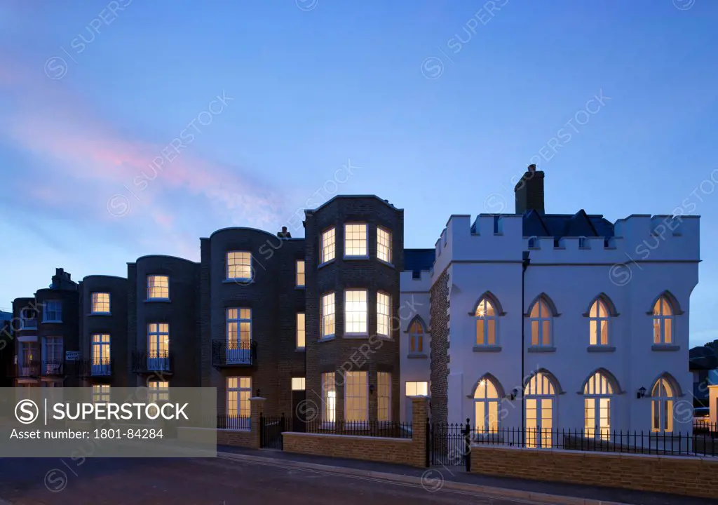Royal Harbour View, Ramsgate, United Kingdom. Architect Madigan Browne Architects, 2013. View of streetat dusk showing mixed new build housing in a Georgian and Victorian pastiche style.