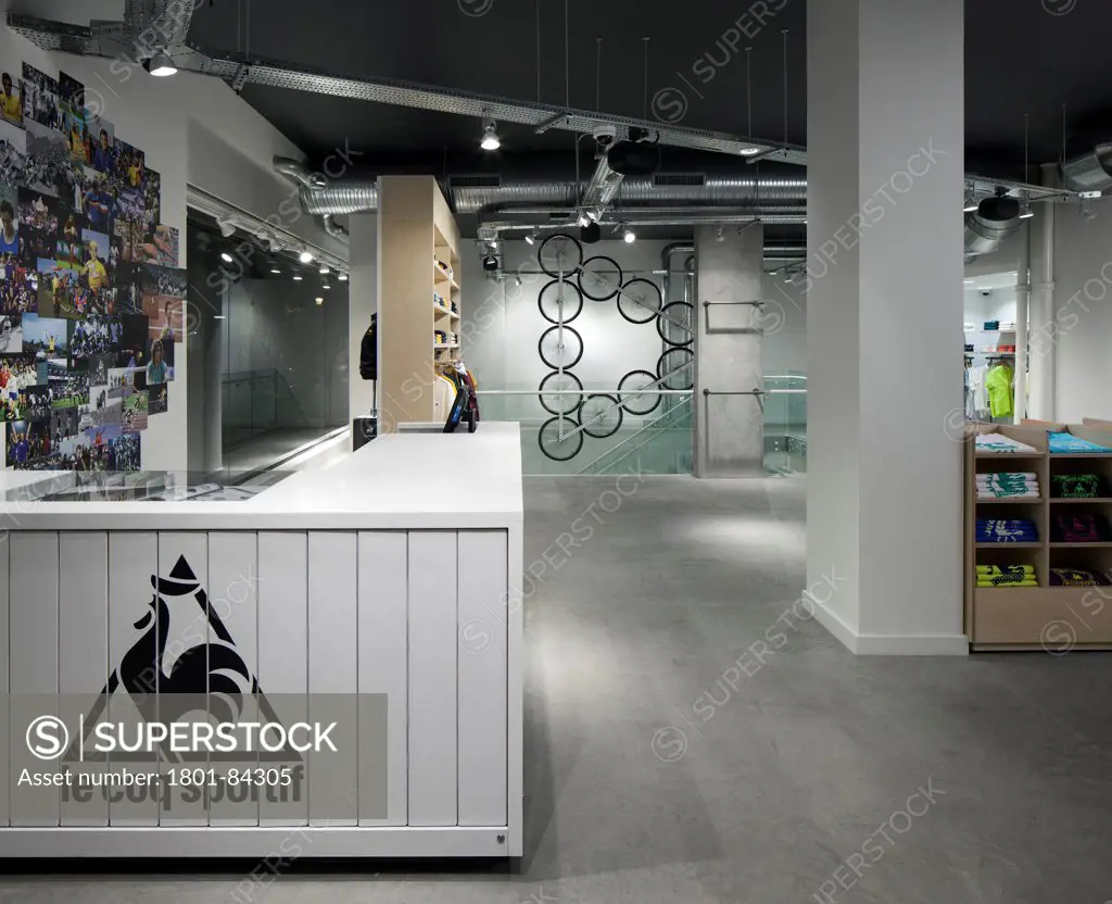 Le Coq Sportif London -FlagshipStore, London, United Kingdom. Architect Studio Oscar, 2013. Store counter and till, merchandise and sculpture can be seen in the background.
