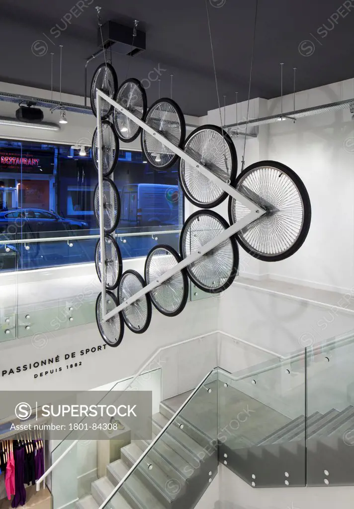 Le Coq Sportif London -FlagshipStore, London, United Kingdom. Architect Studio Oscar, 2013. Interior of the store showing the Kinetic Bicycle Sculpture hanging over the stairs.