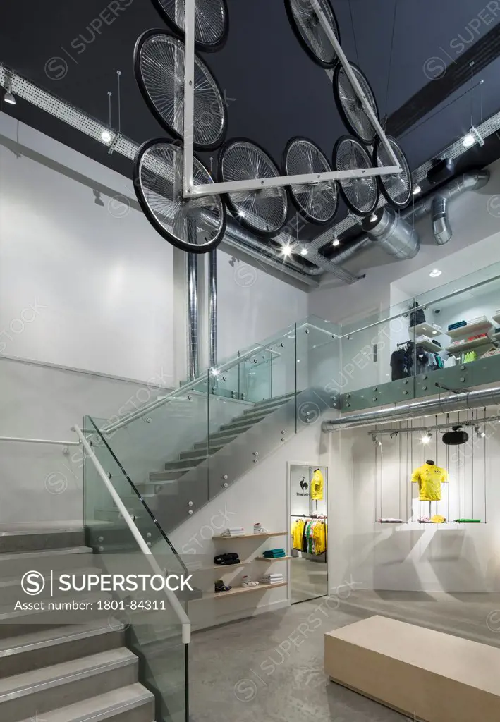 Le Coq Sportif London -FlagshipStore, London, United Kingdom. Architect Studio Oscar, 2013. Super wide shot of the Interior of the store showing the Kinetic Bicycle Sculpture hanging over the stairs.