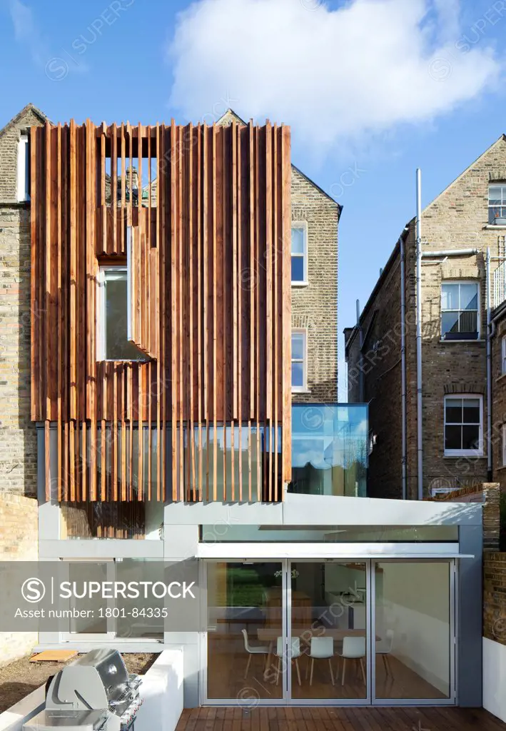 Power House, London, United Kingdom. Architect Paul Archer Design, 2013. View from the garden showing thesculptural timber clad rear extension. The upper floors of the extension are clad with a skin of Douglas fir battens.