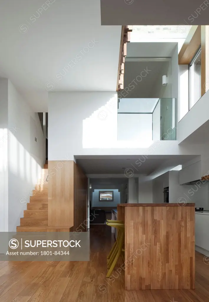 Power House, London, United Kingdom. Architect Paul Archer Design, 2013. View looking back into the house showing the kitchen island area and staircase.