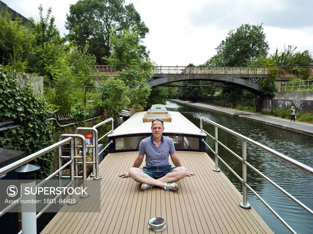 Narrowboat, London, United Kingdom. Architect Pete Young, 2013. Pete Young on sun deck.