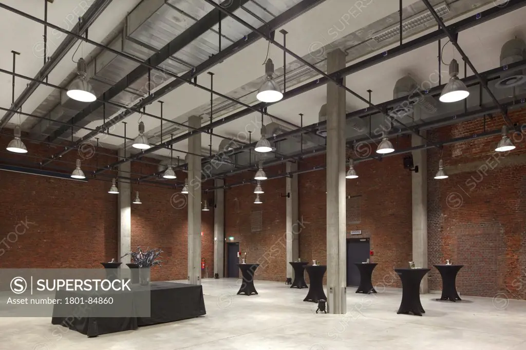 Banqueting hall with concrete pillars, exposed metal pipework and brick walls