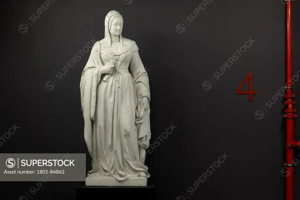 Historic statue on fourth floor against black wall with red '4' graphic and red pipework