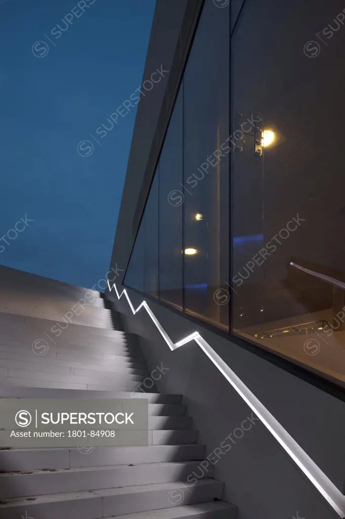 Illuminated staircase in dry dock against cloudy sky at dusk