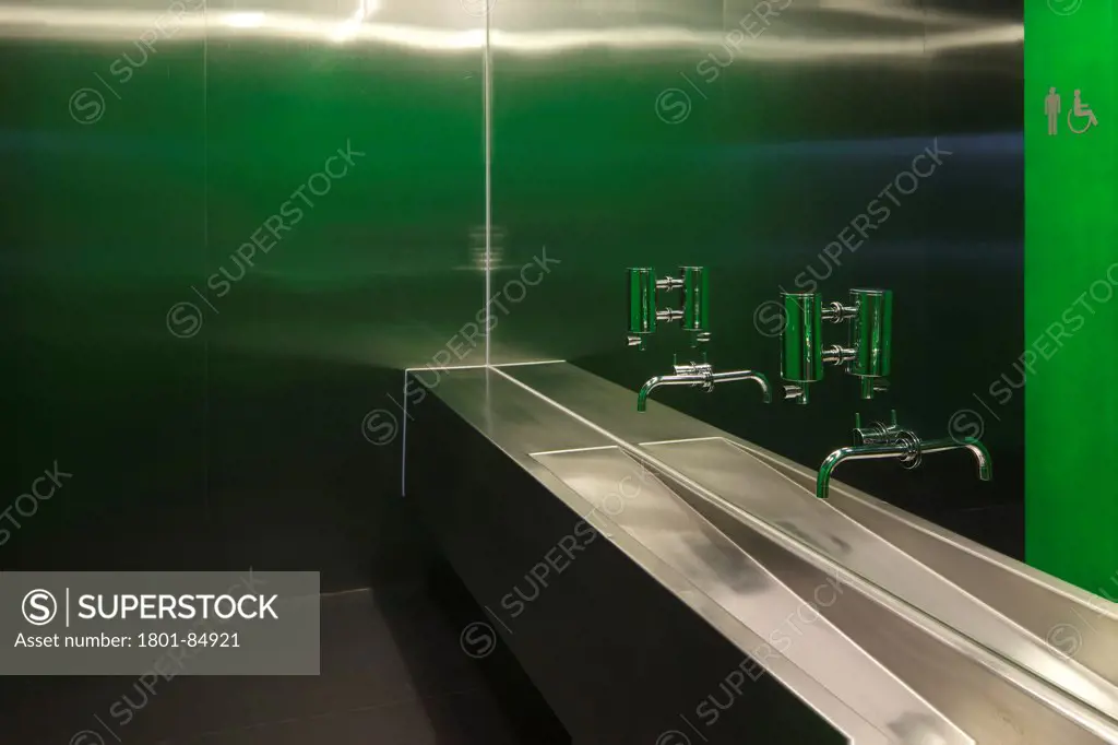 Steel washbasin and metallic panels with green wall in lavatories