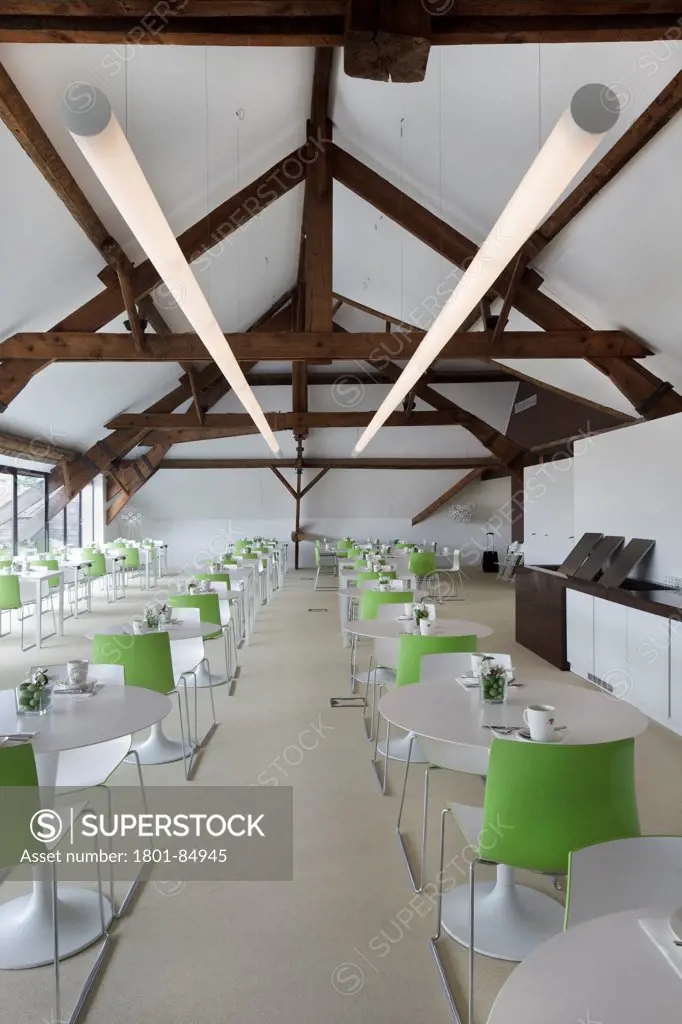 Top floor dining room with green chairs, white walls and floor and original beams