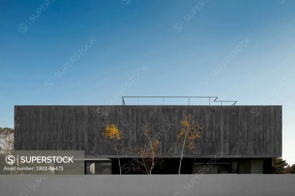 House in Aldeia do Juso, Aldeia do Juso, Portugal. Architect ARX Arquitectos, 2011. View of elongated concrete facade.